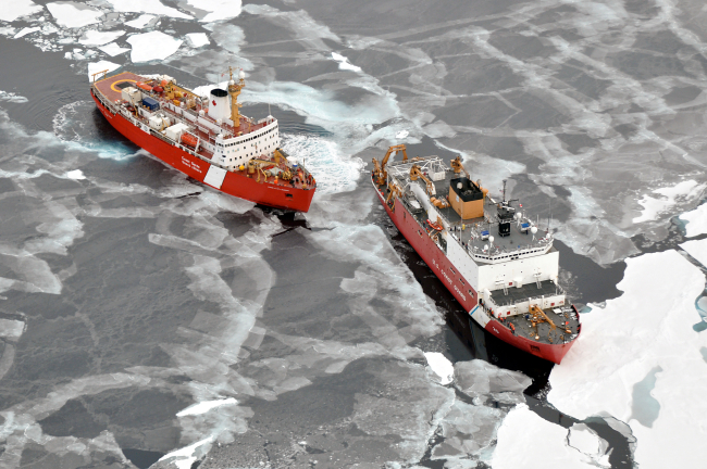 USCG icebreaker HEALY in relatively smooth first-year ice floes and nilas icefollowed by the Canadian Coast Guard icebreaker LOUIS S