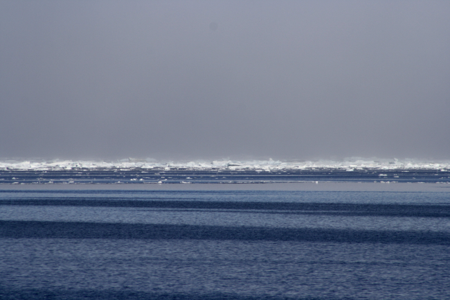 Parallel patterns in the waters of the Beaufort Sea with ice floes and apressure ridge in the distance