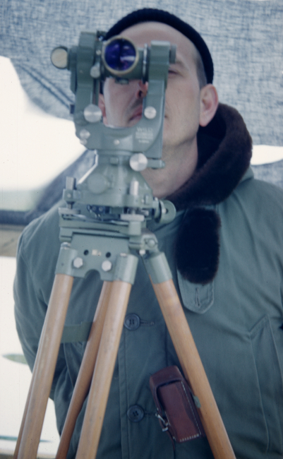 Observing angles with a theodolite on a chilly day in the Aleutian Islands