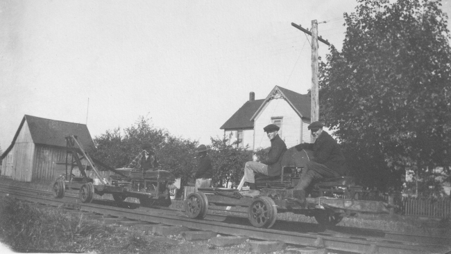 Level crew using motorized speeders on railroad