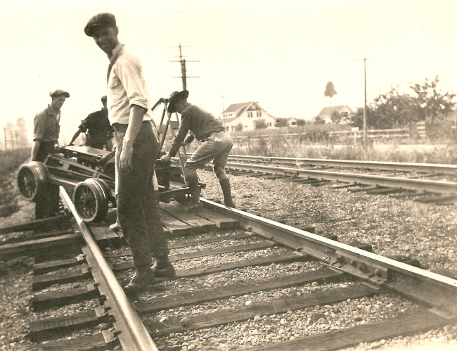 Level crew placing speeder on tracks preparing to head to day's work