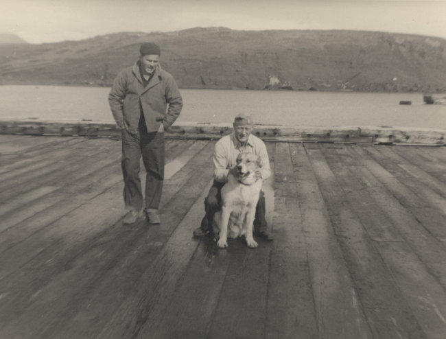 Boatswain Petersen with dog and Woodrow Gholston on pier at Kiska