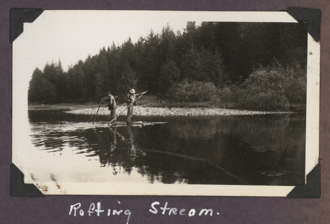 Work party crossing small stream on improvised raft