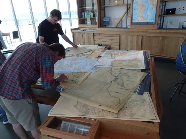 Visitors inspecting historic Coast and Geodetic Survey charts at San FranciscoExploratorium
