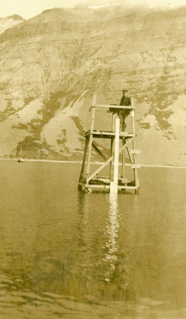 Lieutenant Ray Schoppe checking a tide gage built on a platform