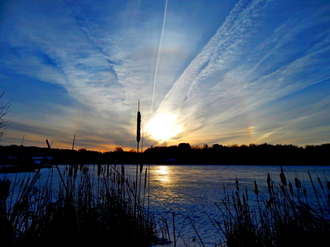 Sunrise icebow cut by jet contrails