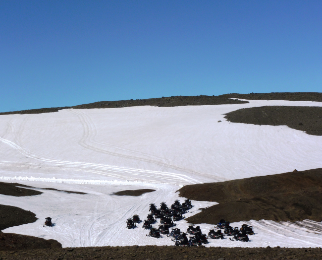Skidoos stand ready on a diminishing ice cap in Iceland