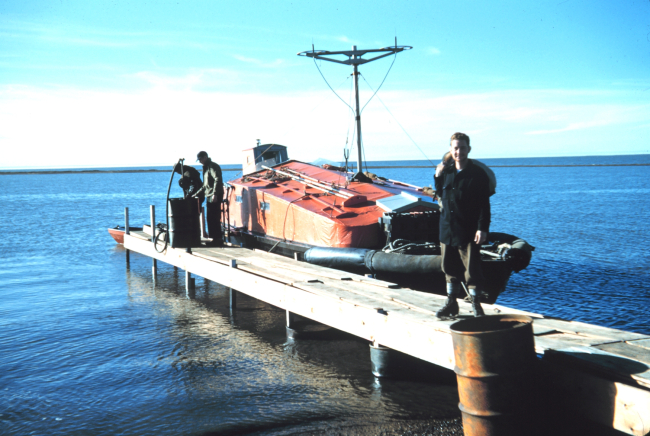 Survey launch tied up and fueling at a home-made pier
