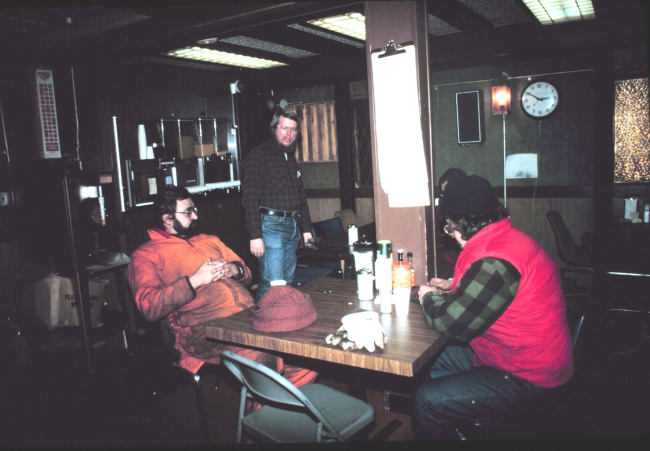 The South Pole dining room with station leader Ron Peck standing; Daryl Leedseated on the right