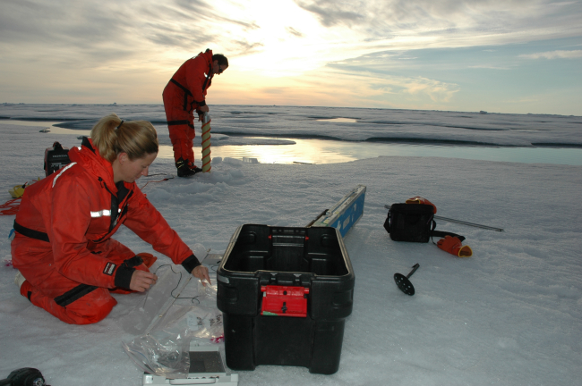 Rolf Gradinger works on an ice core while Mette Nielson takes measurementson a core already brought to the surface