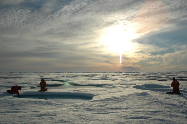Scientists work on ice over the deep Arctic Ocean