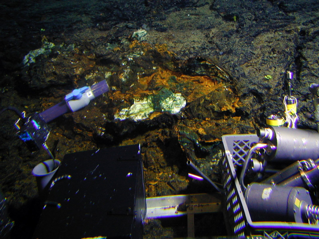Sampling hydrothermal oxide/silica crusts and a sponge at Clark Volcano (994 meters depth)