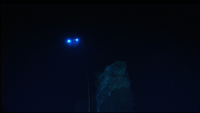The lights from the Hercules ROV are seen 30-meters away as theROV is maneueved in the vicinity of a rock outcrop