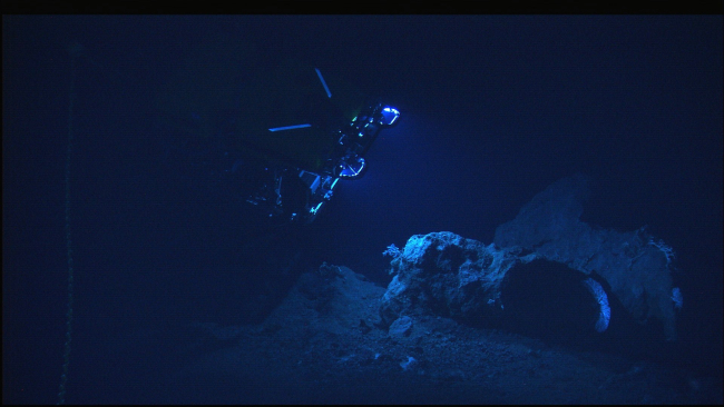 The Hercules ROV is being maneuvered in the vicinity of rock outcrops