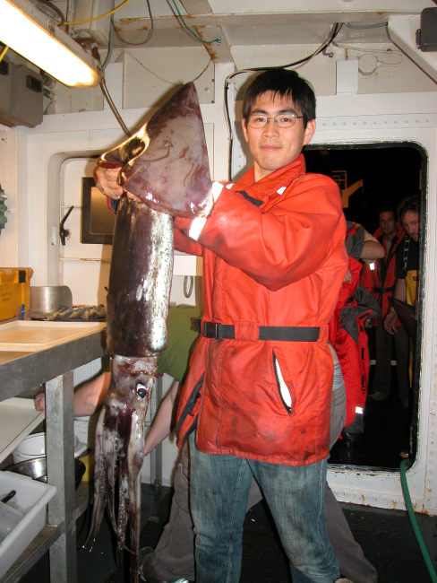 Visiting scientist holding large squid