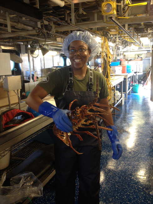 Survey technician Adria McClain holding a spiny lobster,
