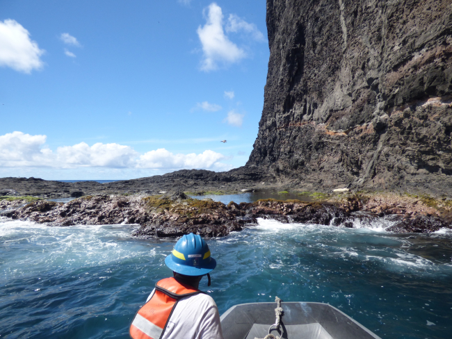 Monk seal researchers approach a rocky ledge at Nihoa Island