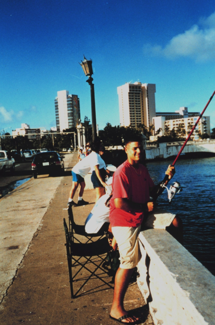 A young man trying his luck in the Laguna del Condado from the Route 25 Bridge