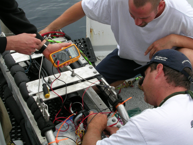 Dave Read, Matt Barnhart, and John Harms work on an underwatercamera system aboard the F/V SEAHORSE