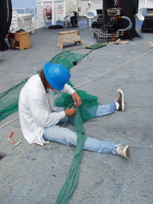 Lead Fisherman Jonathan Saunders sews in the liner of a sampling trawl net