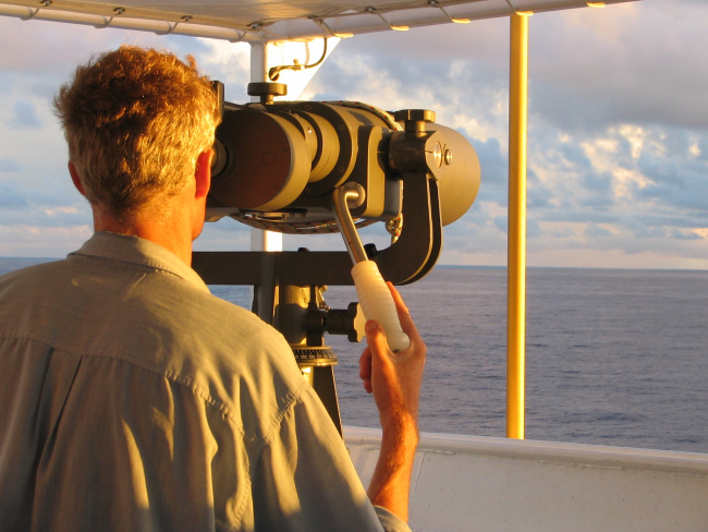 Hugh Finn looking through the Big Eye binoculars aboard the NOAA shipOscar Elton Sette on a PISC cetacean research cruise