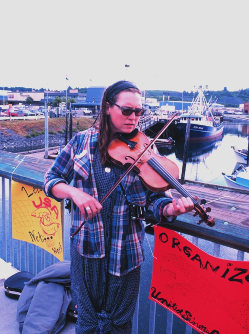 A violinist plays at the community fish fry in support of the United SeinersAssociation