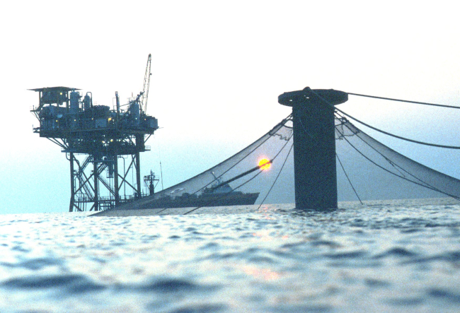 Sunset view of an offshore cage in the Gulf of Mexico near an oil rig