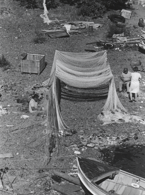 Native Americans repairing gill net on the banks of the Columbia River