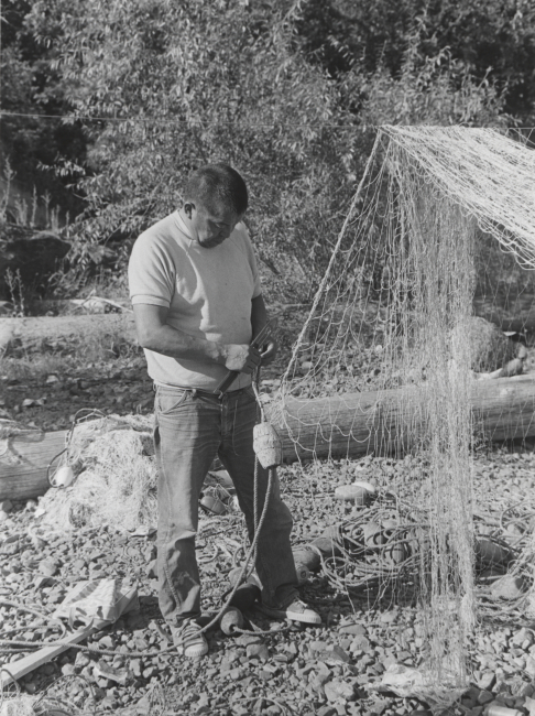 Native American repairing gill net on the banks of the Columbia River