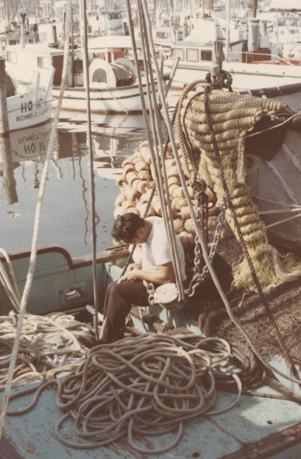 Fisherman performing maintenance on purse seine net
