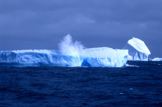 An iceberg at the moment it cleaves a large chunk of ice