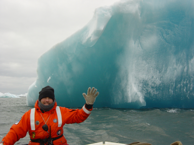 AMLR researcher Adam Jenkins next to an iceberg
