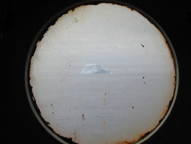 An iceberg seen through the port hole of the R/V Yuzhmorgeologiya