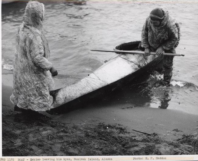 Eskimo exiting kayak on shore