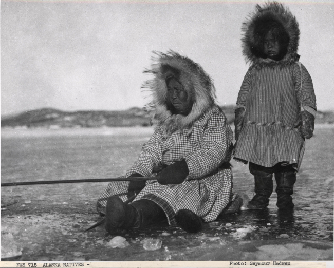 Alaska native eskimo woman and child ice fishing