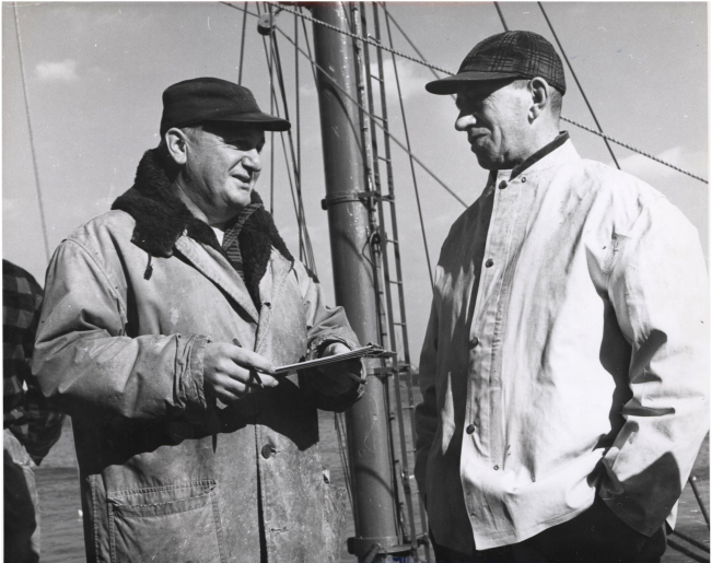 Biological aid John Malone interviewing mate of a large Boston trawler atthe Boston Fish Pier