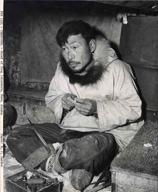 Chief of the King Island eskimos at Nome with ivory carving tools
