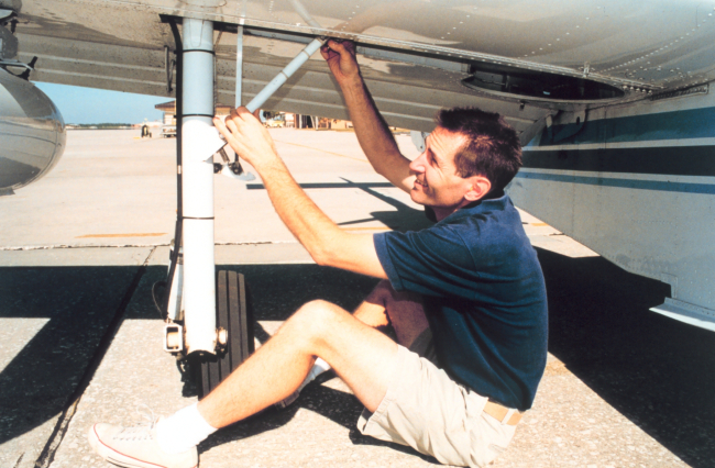Commander Phil Kennedy preflighting NOAA 65