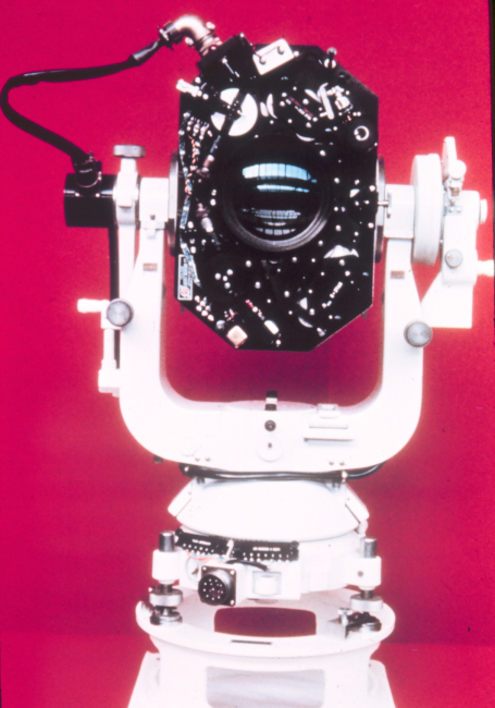 Inside of BC-4 camera showing shutter gears on upper portion of photo,lens in center, and various electronic connections for timing shutter openingand communicating with synchronization unit
