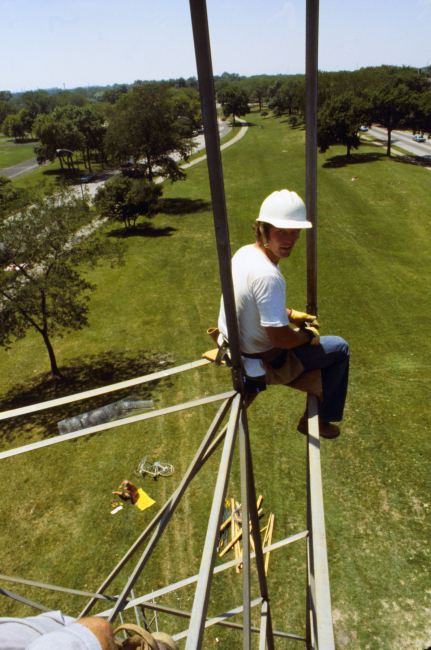 Builder sitting on construction seat setting leg - not a good job for folks with acrophobia!