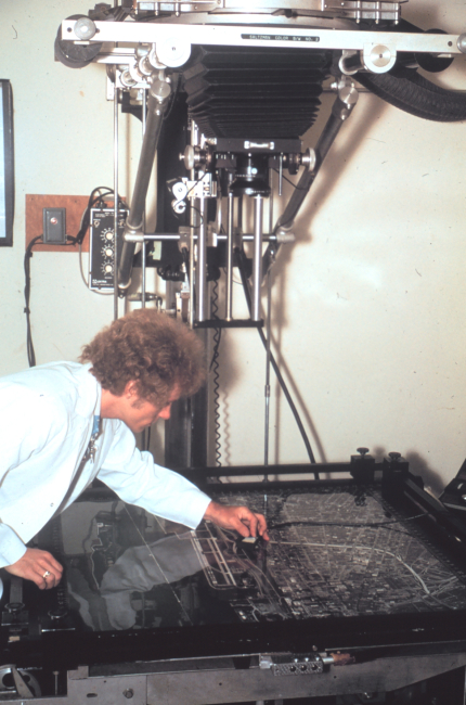 Harvey Carlson operating a photo enlarger at photo processing facility onfirst floor of Herbert Clark Hoover Building (Commerce Building