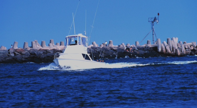 A recreational fishing boat passing the jetties at Manasquan Inlet