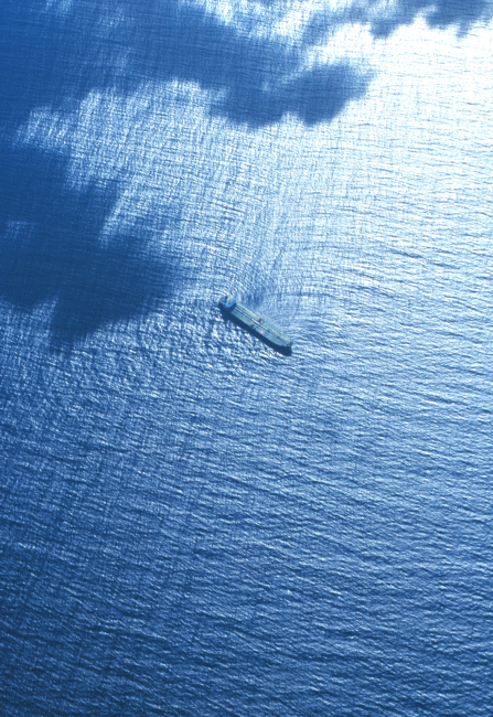 Strange wave refraction pattern apparent in aerial photographas swells encounter large merchant vessel
