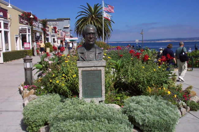A bust of John Steinbeck near waterfront shops along Cannery Row