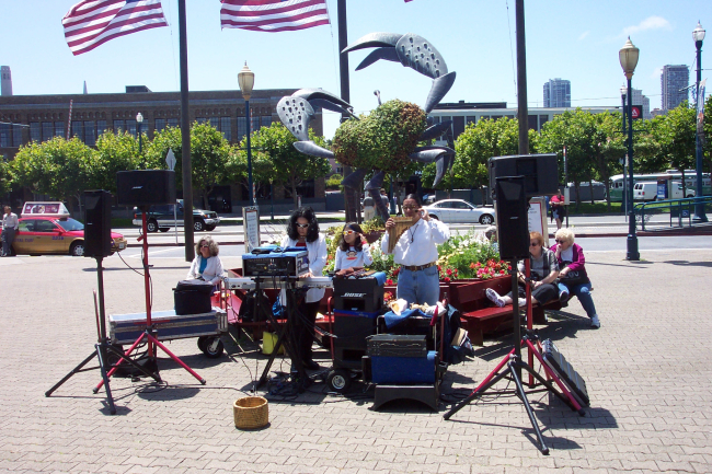 Musicians plying their trade near the crab sculpture at Pier 39