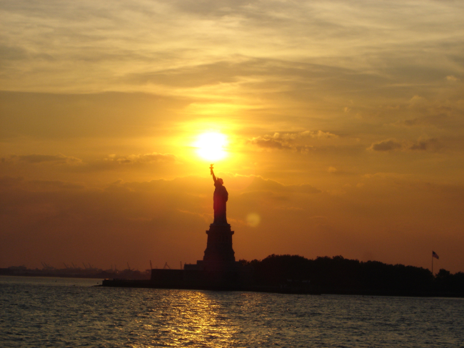The Statue of Liberty at sunset holding the torch of freedom aloft