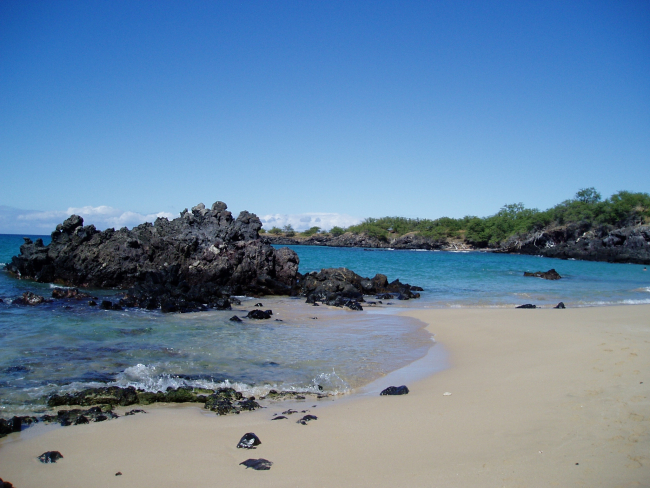 Lava rock and white sand on a quiet cove