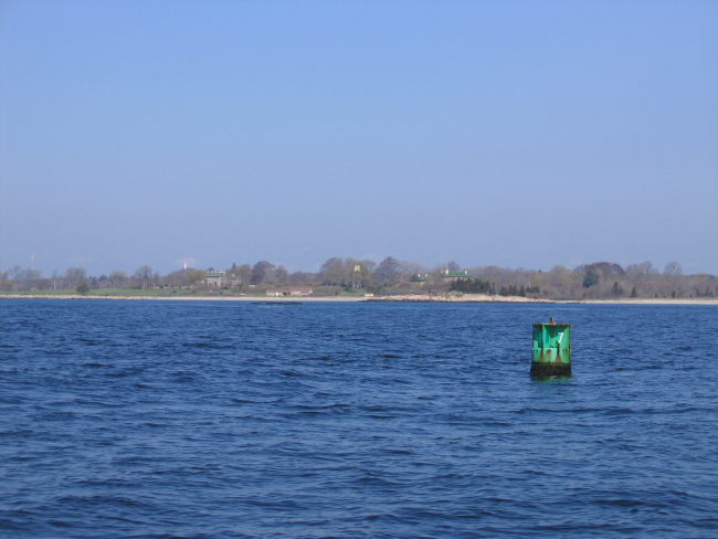 Long Island shoreline looking past a buoy to mansions on the shore
