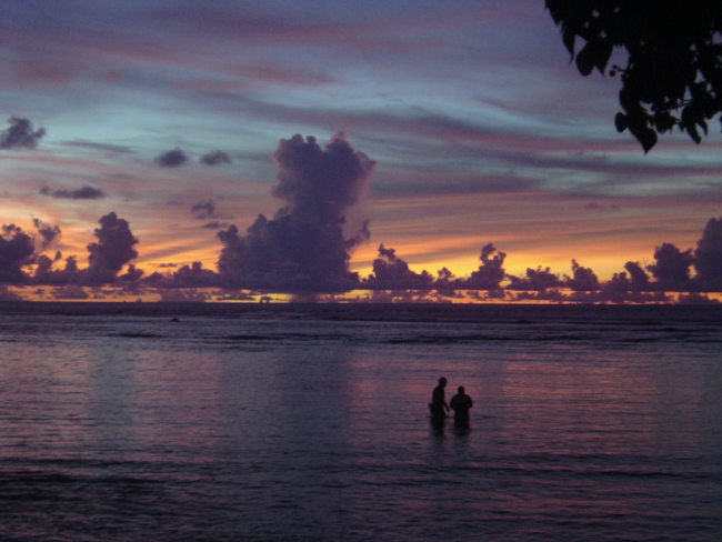 Casting the net in a quiet lagoon at sunset on Guam