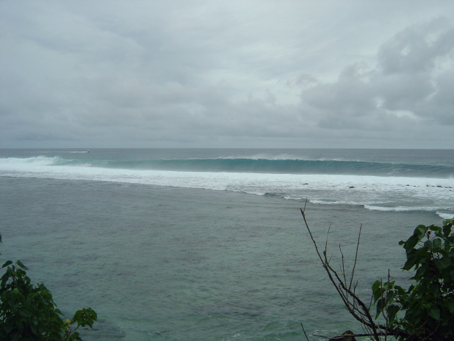 An offshore wind hollows out the long Pacific swell striking the Guam reef